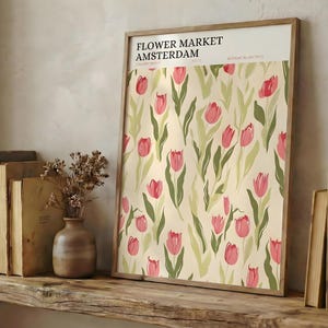 Rustic wooden shelf styled with vintage books and a framed detailed Amsterdam pastel pink tulip poster.