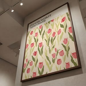 Dynamic low angle view looking up at a large retro Amsterdam flower market tulip poster hanging high on a gallery wall.