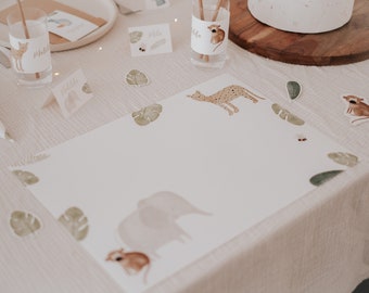 May include: A white placemat with a jungle animal theme. The placemat features a cheetah, an elephant, a monkey, and leaves. The placemat is perfect for a jungle-themed party.
