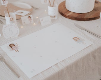 May include: White table setting with a white placemat featuring a fairy illustration. The placemat has a number "5" in a floral wreath. A silver fork and knife are on the table.