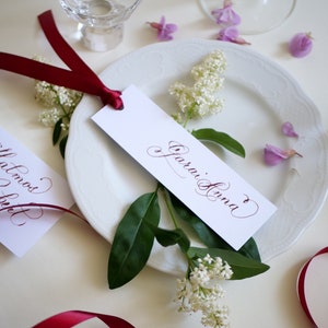 Segnaposto per matrimonio con nastro rosso vino Etichette con nome calligrafiche scritte a mano Decorazione per la tavola di nozze Etichette con nome scritte per cena