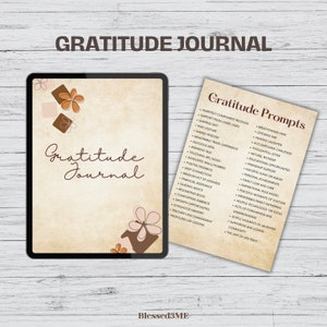 May include: A digital tablet with a brown background and the text "Gratitude Journal" in brown lettering. The tablet is decorated with brown and pink floral illustrations. A separate sheet of paper with the text "Gratitude Prompts" in brown lettering lists a variety of prompts for a gratitude journal.