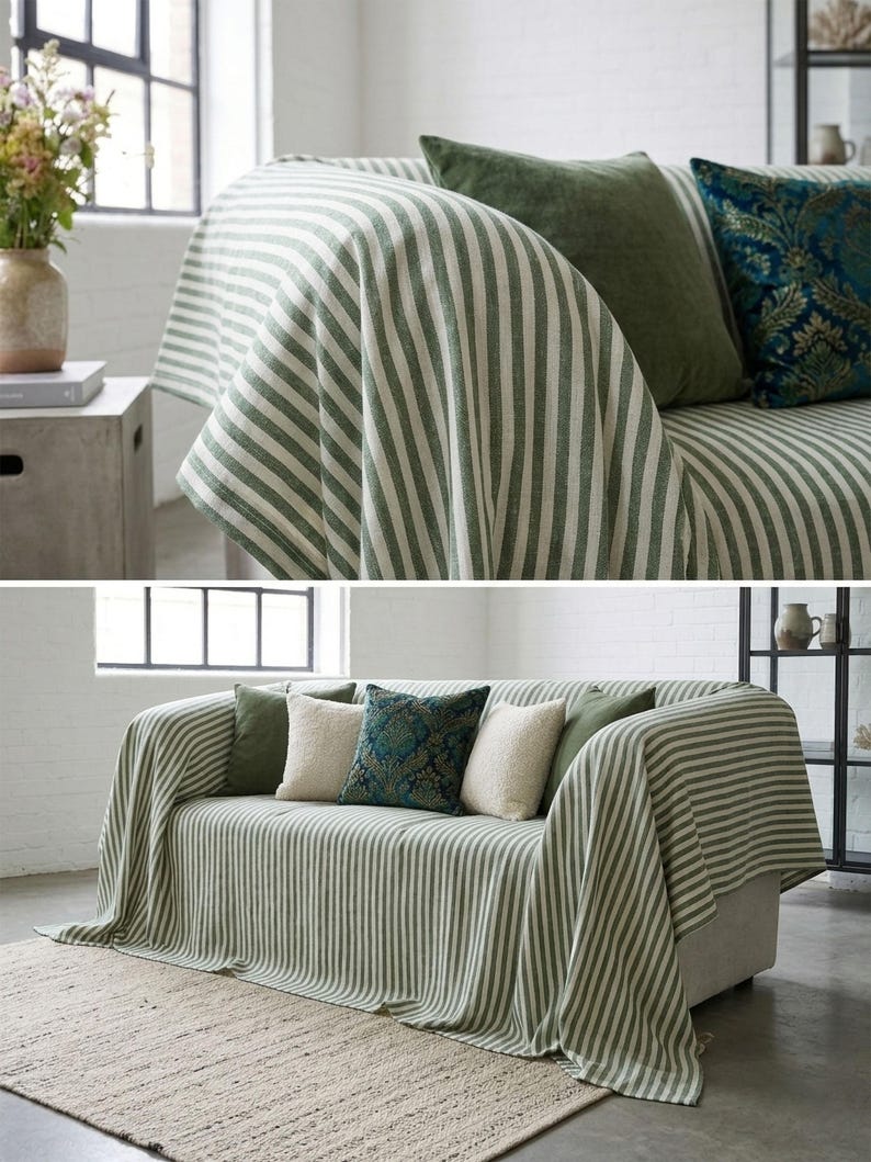 May include: A sofa draped with a green and white striped throw blanket. The sofa is adorned with several throw pillows in shades of green, cream, and teal. The room has a neutral color palette with a rug and a vase of flowers.