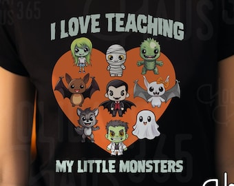 Könnte beinhalten: Schwarzes T-Shirt mit einem orangefarbenen Herzen, auf dem Comic-Monster abgebildet sind. Der Text "Ich liebe es, meine kleinen Monster zu unterrichten" ist auf das Shirt gedruckt.