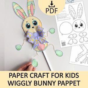 Puede incluir: Una marioneta de conejito de papel de colores con un lazo morado y detalles verdes. La imagen incluye un icono de descarga PDF e instrucciones de montaje. El texto en la parte inferior dice "PAPER CRAFT FOR KIDS WIGGLY BUNNY PAPPET".