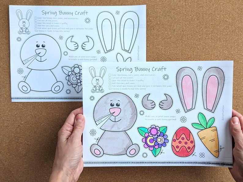 May include: Two sheets of paper with a "Spring Bunny Craft" design. The design includes a bunny, bunny ears, thumbs up, flowers, an egg, and a carrot. The bunny is gray with a pink nose. The text on the paper includes instructions.