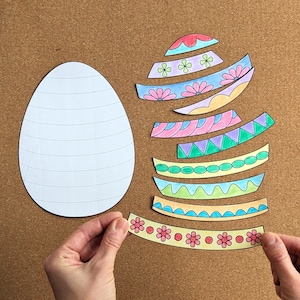 Pode incluir: Um projeto de artesanato com um contorno de ovo branco e tiras de papel coloridas e estampadas. As tiras t&ecirc;m desenhos florais e geom&eacute;tricos em v&aacute;rias cores, sugerindo um tema de P&aacute;scoa ou primavera.