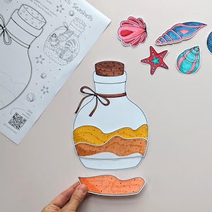 May include: A craft project featuring a jar illustration with a cork and a tied ribbon. The jar is filled with layers of yellow and brown. Several seashell cutouts in pink, blue, and green are scattered around the jar. A sheet of paper with the title "Seashells" is also present.