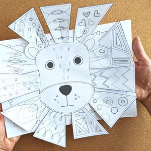 May include: A black and white lion art project with a detailed face and patterned mane. The mane is made of triangular pieces with various designs, including hearts, circles, and geometric shapes. The project is held against a corkboard background.