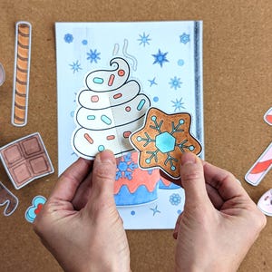 Peut inclure: Illustration festive d'un dessert en papier avec de la cr&egrave;me fouett&eacute;e et un biscuit pain d'&eacute;pices. Des d&eacute;coupes suppl&eacute;mentaires incluent un sucre d'orge, des guimauves et du chocolat. L'image est sur fond neutre.