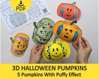 May include: A set of paper 3D Halloween pumpkins featuring various colors including orange, yellow, and green with hand-drawn facial expressions and patterns. The pumpkins are displayed alongside a printed PDF instruction sheet with diagrams.