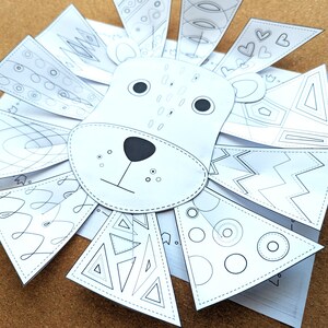 May include: A white paper lion craft with a black nose, eyes, and whiskers. The lion's mane is made of triangular and heart-shaped paper pieces, each decorated with geometric patterns. A fun DIY craft project.
