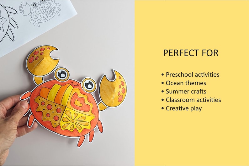 Op de afbeelding: Een papieren uitsnede van een krab met een gesegmenteerd schild met oranje, gele en rode patronen, grote ogen en twee scharen. De tekst rechts luidt: PERFECT FOR Preschool activities, Ocean themes, Summer crafts, Classroom activities, Creative play.