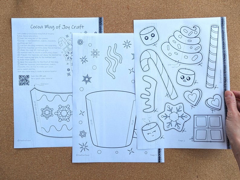 Peut inclure: Trois feuilles de papier blanc avec des dessins au trait noirs pour un bricolage de tasse de cacao. Les feuilles comprennent des instructions, un mod&egrave;le de tasse et des formes d&eacute;coup&eacute;es de guimauves, de cannes en bonbon et de flocons de neige. Le texte "Cocoa Mug of Joy Craft" est visible.