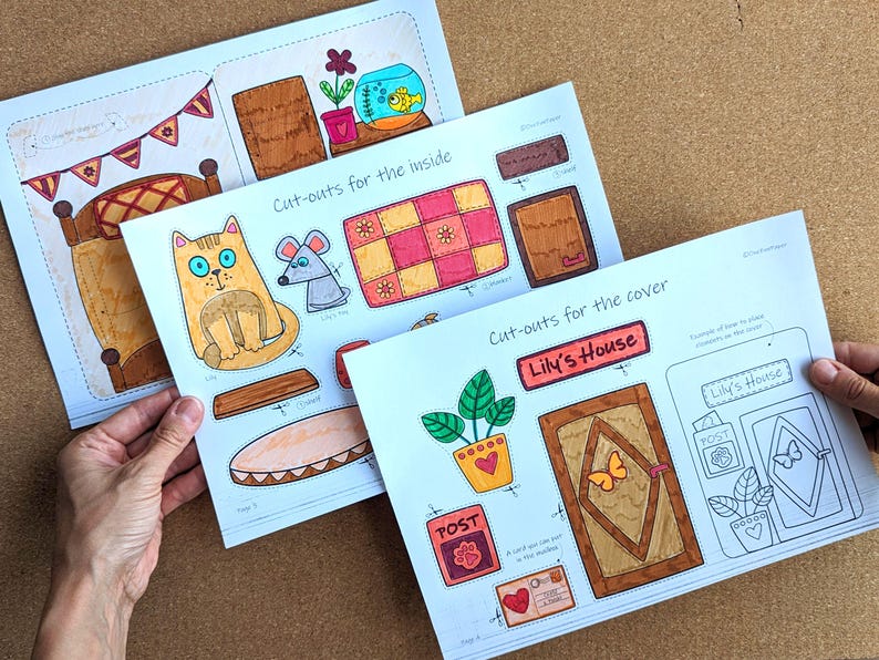 May include: Three sheets of paper with colorful, hand-drawn cut-out illustrations for a child's craft project. The sheets include images of a cat, mouse, bed, door, and other decorative elements. Text includes "Cut-outs for the inside" and "Lily's House".