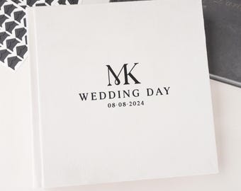 May include: White wedding album with the initials "MK" and the text "Wedding Day 08-08-2024" printed in black.