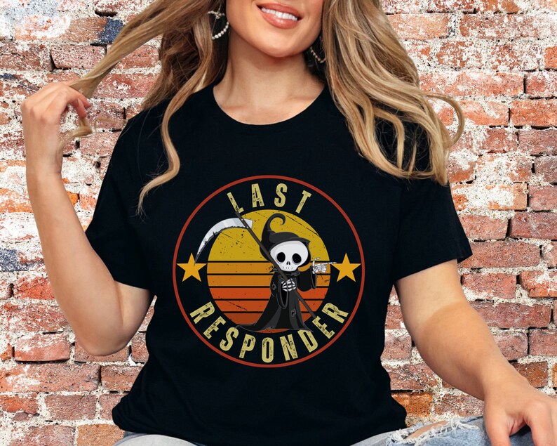 May include: Black t-shirt with a retro-style graphic of a cartoon Grim Reaper holding a scythe and a beer mug. The graphic is surrounded by a circle with the text "Last Responder" in white.