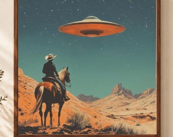 May include: A square framed wall art print depicting a desert landscape with a rider on horseback wearing a cowboy hat, looking up at a glowing orange UFO hovering in a dark starry sky above rocky terrain and sparse desert vegetation.