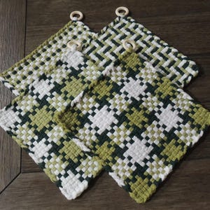 May include: Four woven pot holders with a green and white checkered pattern. Each pot holder has a wooden ring attached to the top corner.