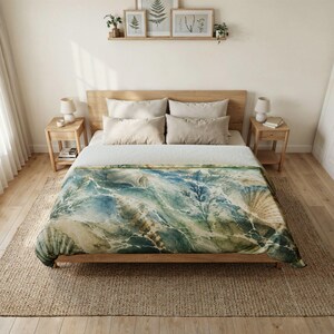 May include: A bed featuring a quilt with a watercolour print of seashells and seaweed in shades of blue, green, and cream. The bed has a wooden frame, two matching wooden nightstands with lamps, and four beige pillows arranged against a wooden headboard.