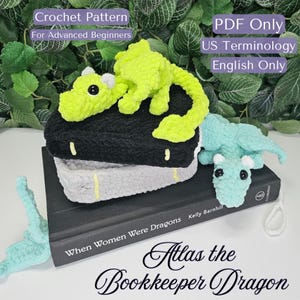 May include: Crochet pattern for a green and blue dragon amigurumi. The pattern is for advanced beginners and uses US terminology. The pattern is written in English only. The image shows the finished amigurumi dragons on a book titled "When Women Were Dragons".