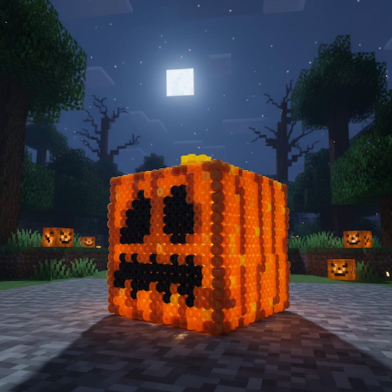 May include: A pixelated orange pumpkin with black eyes and a mouth, lit from within, sits on a stone path. The background features a night scene with trees, a full moon, and other lit pumpkins, creating a Halloween theme.