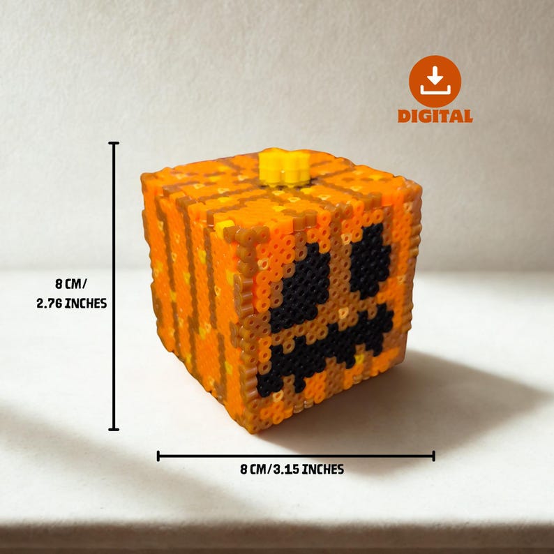 May include: A cube-shaped, orange and black pixel art pumpkin with a yellow stem. The pumpkin is 3.15 inches wide and 2.76 inches tall. The face has a carved-out design. The word "DIGITAL" is in the upper right corner.