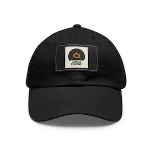 May include: Black baseball cap with a curved brim. The cap features a rectangular patch with the words "CHECK ENGINE" below an orange engine light icon. The hat is made of a durable fabric and has an adjustable strap.