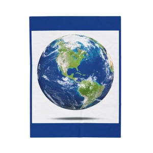May include: A blue and white blanket featuring a detailed image of Earth. The planet is depicted with green landmasses, blue oceans, and white clouds. The blanket has a blue border and a white background.