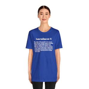 Puede incluir: Una camiseta azul real con el texto "Amendment IV" en blanco, seguido del texto de la Cuarta Enmienda. La camiseta es de cuello redondo y manga corta.