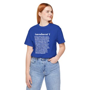Puede incluir: Una camiseta azul real con el texto "Amendment V" y el texto de la Quinta Enmienda en blanco. La camiseta está hecha de un material suave y es adecuada para el uso diario.