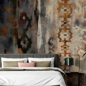 May include: Bedroom with a grey upholstered headboard, white bedding, and decorative pillows. The wall features an abstract mural with brown, grey, and black geometric patterns. A green plant in a white pot is on the right.