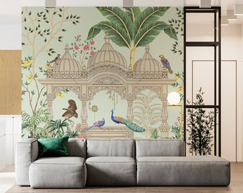 May include: A light green wallpaper with a detailed illustration of a white ornate structure with peacocks, birds, and palm trees. The wallpaper is in a living room setting with a gray couch and a green pillow.