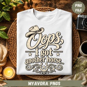 Peut inclure: Un t-shirt blanc avec une impression graphique représentant un chapeau de cowboy au-dessus du texte "Oops, I got another horse..." et une icône de fer à cheval. Le motif inclut des volutes et des étoiles beiges et noires sur le devant.