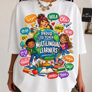 Peut inclure: Un t-shirt blanc avec un motif coloré représentant un globe terrestre et le texte "PROUD TO TEACH MULTILINGUAL LEARNERS". Le dessin inclut deux enfants, des piles de livres, des crayons, une pomme et des bulles avec des salutations variées.