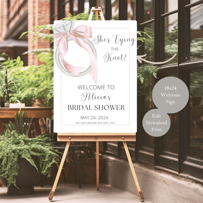 May include: A printable bridal shower welcome sign with a watercolor illustration of a ring with a pink bow. The sign says "She's Tying the Knot!" and "Welcome to Alicia's Bridal Shower" with the date "May 24, 2024".