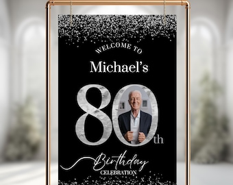 May include: Black and silver welcome sign with a photo of a person and the text "Welcome to Michael's 80th Birthday Celebration".