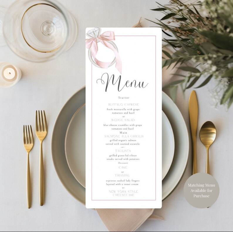 May include: A wedding menu with a watercolor illustration of a ring with a pink ribbon. The menu includes a starter, salad, main course, dessert, and a note that matching menus are available for purchase.