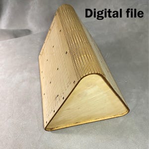 May include: A light-colored wooden triangular object with a curved top and a grid pattern on one side. The text "Digital file" is visible in the upper right corner. The object appears to be made of thin, layered wood.