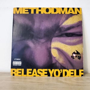 May include: A 12" single record album cover featuring a close-up of a person's face in purple and yellow tones. The album title "METHOD MAN" is in yellow block letters at the top, and "RELEASE YO'DELF" is at the bottom.