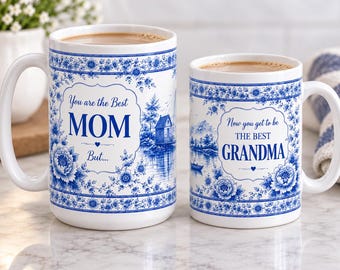 May include: Two white ceramic mugs with blue floral patterns and landscape illustrations. The larger mug features the text "You are the Best MOM But..." and the smaller mug features the text "Now you get to be THE BEST GRANDMA".