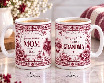 May include: Two white ceramic 11oz mugs with a maroon floral toile pattern. The left mug reads: You are the Best MOM But... The right mug reads: Now you get to be THE BEST GRANDMA. Both feature a small landscape illustration of a house and boat.