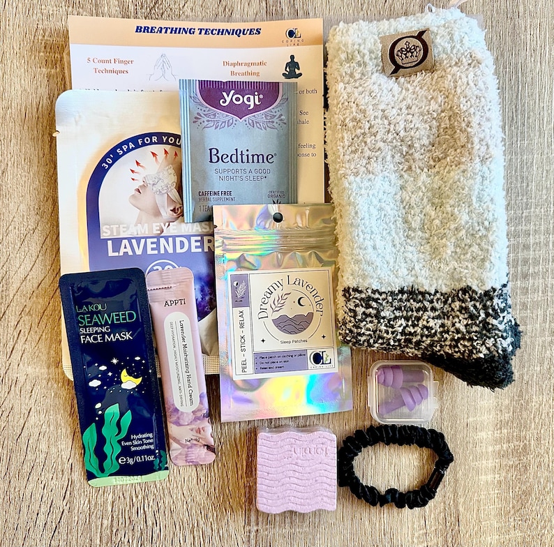 May include: A selection of sleep aids, including fluffy socks, lavender-infused products, earplugs, and a hair tie. The items are arranged on a wooden surface, with text that reads "Breathing Techniques" and "Bedtime".
