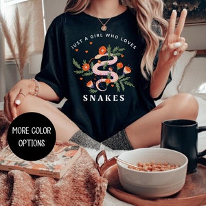 May include: Black t-shirt with a graphic of a snake with flowers and the text "Just a girl who loves snakes".