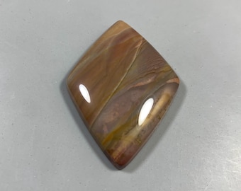 May include: A polished, diamond-shaped gemstone with a mix of warm colors. The stone features bands of brown, red, and yellow hues, with a glossy finish. The gemstone is likely used for jewelry or decorative purposes.