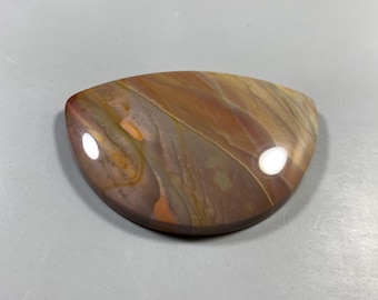 May include: A polished, teardrop-shaped stone with a glossy finish. The stone features a swirling pattern of brown, orange, and tan hues. The surface reflects light, creating bright white spots. This decorative stone is ideal for jewelry making or display.