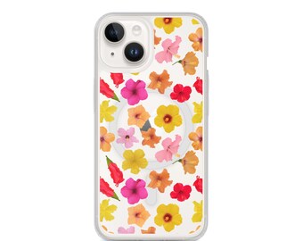Puede incluir: Funda transparente para teléfono con un colorido estampado floral. La funda presenta una variedad de flores en tonos amarillos, rosas, naranjas y rojos, sobre un fondo blanco. Tiene un borde transparente y un área de carga magnética circular.