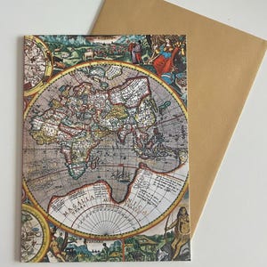 May include: A vintage-style greeting card featuring a detailed world map illustration with a brown envelope. The map is in shades of brown, beige, and blue, with decorative figures and text. The card is rectangular and has a classic, historical aesthetic.