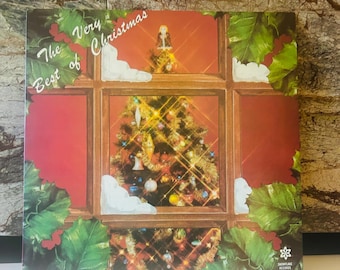 May include: A vintage vinyl record album cover featuring a Christmas tree decorated with ornaments and lights. The cover is red with a window frame and the text "The Best of Very Christmas" in white. The album is from Snowflake Records, ST 111.