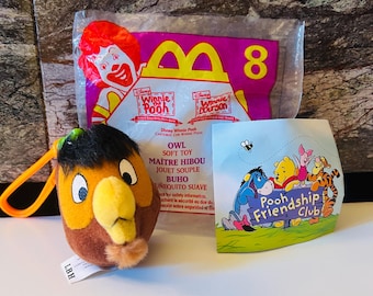 Könnte beinhalten: Eine Sammlung von Artikeln zum Thema Winnie Puuh. Enthält ein Plüsch-Eulenspielzeug, eine McDonald's Happy Meal-Tüte mit der Nummer 8 und eine kleine Karte mit Winnie Puuh-Figuren und dem Text "Poohship Friendship Club".